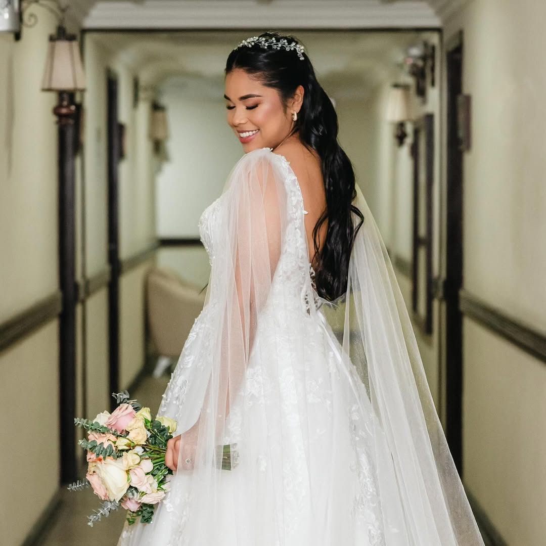 Novia junto a la ventana en una celebración de boda.