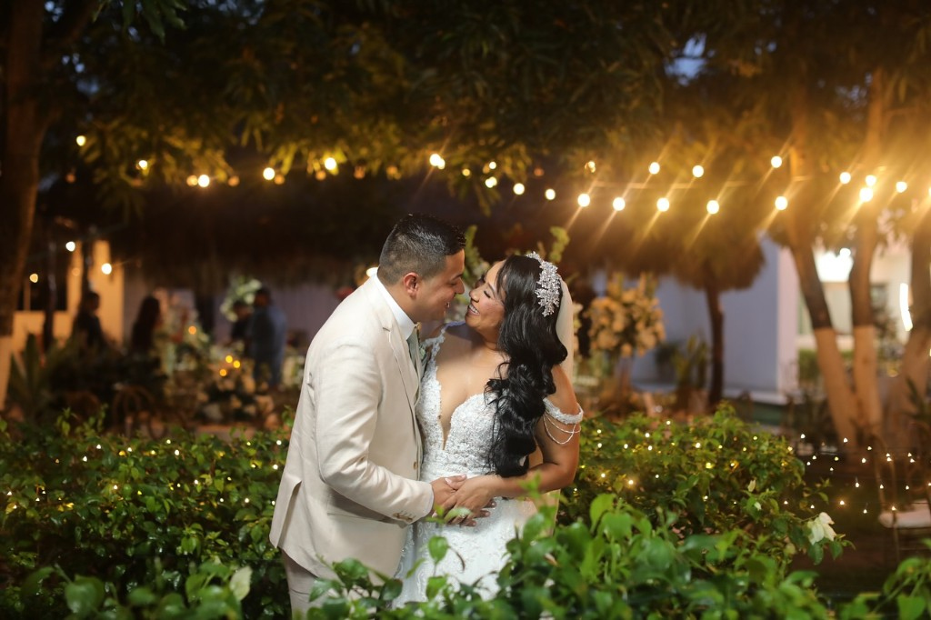 Pareja bajo luces de jardín en una celebración de boda.