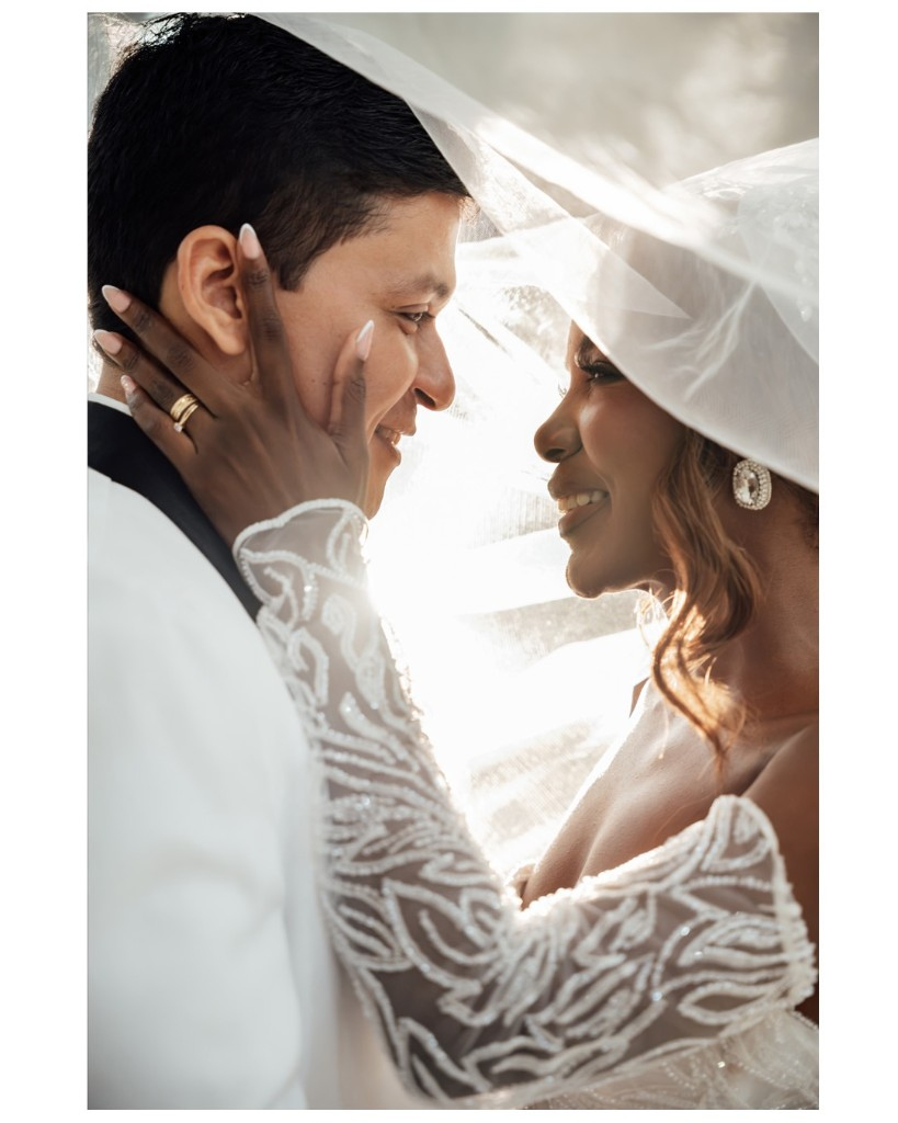 Abrazo bajo el velo en una celebración de boda.